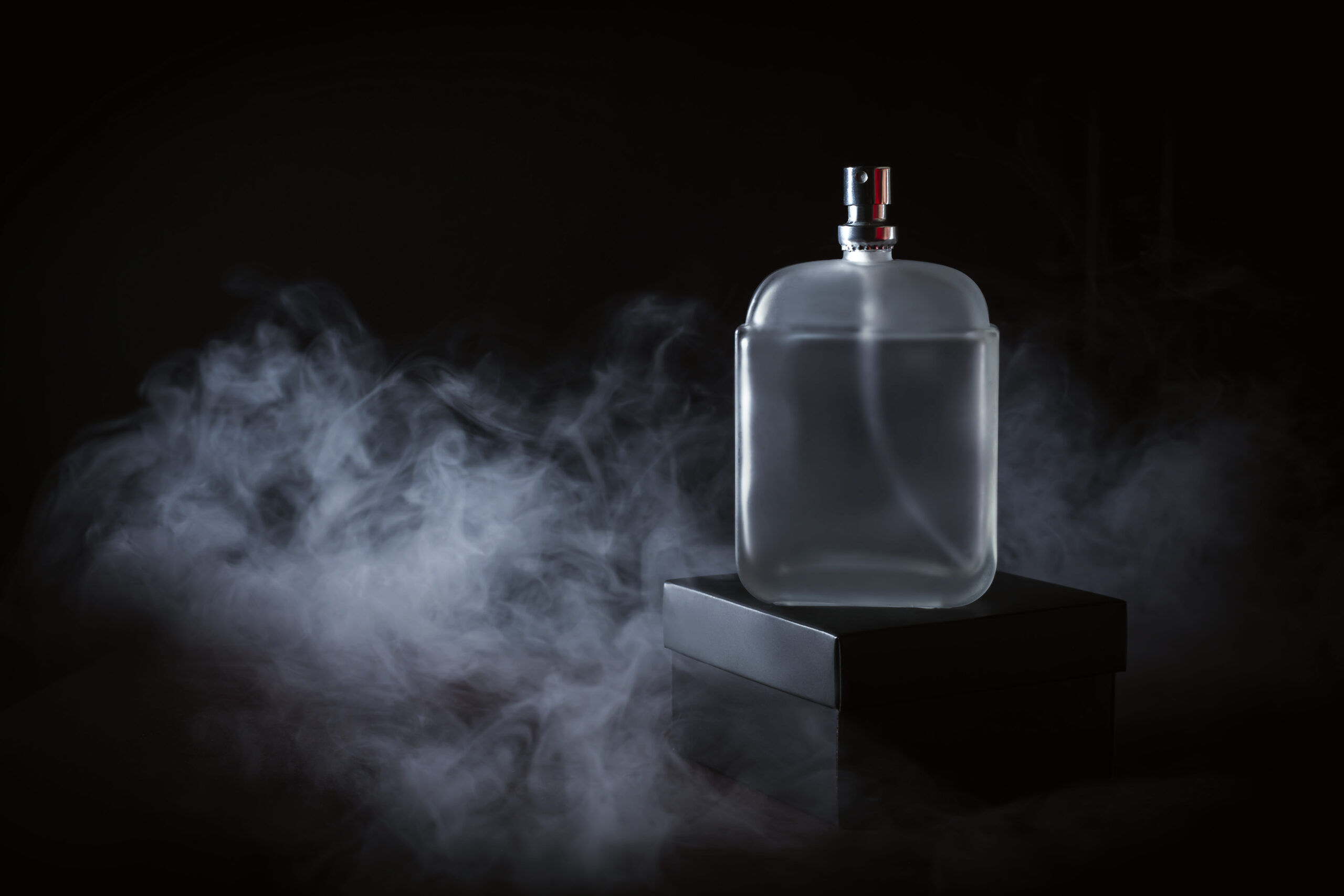 Men's perfume in smoke on a black background